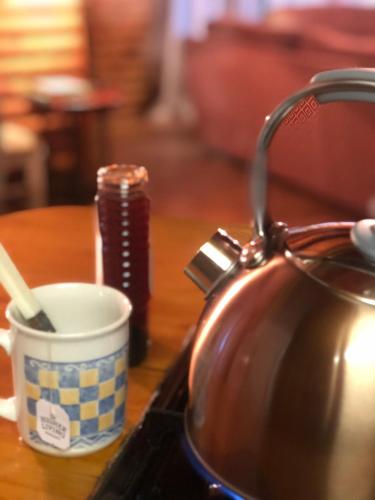 a tea kettle and a cup on a table at Clarens Log Cabin in Clarens