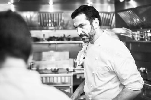 a man standing in a kitchen looking at a person at Villa Bordeaux in Fira