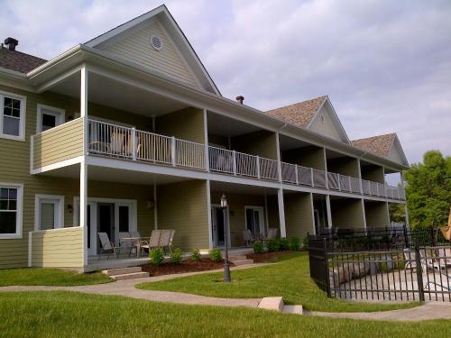 a large yellow house with a porch and balcony at Condo Le Champlain - 105 in Bromont
