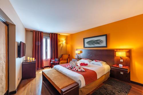 a hotel room with a bed with two dolls on it at Hotel de Berny in Antony