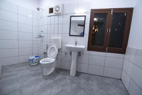 a bathroom with a toilet and a sink at Hotel Mayur in Gorakhpur