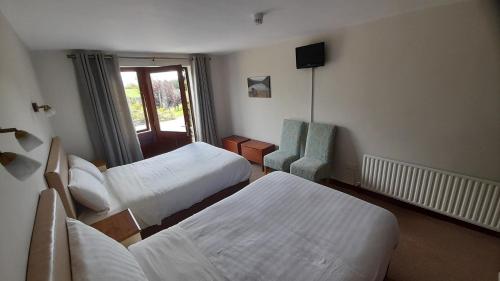 a hotel room with two beds and a chair at Inveraray Farm in Beaufort