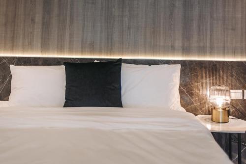 a bed with white sheets and a lamp on a table at AiMen Homestay in Huxi