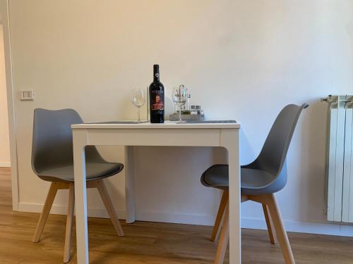a table with a bottle of wine and two chairs at SMartspot Rosia in Rosia