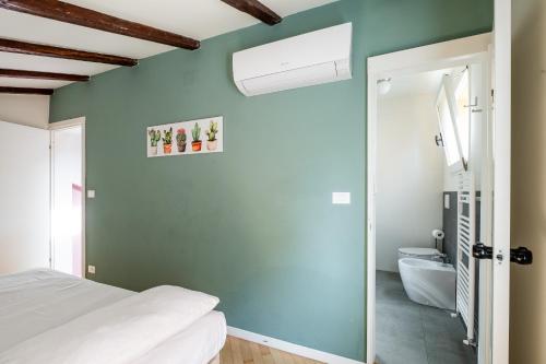 a bedroom with a green accent wall and a bed at Appartamento al Pratello nel cuore pulsante della citta' in Bologna