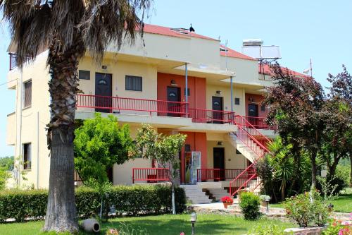 a building with red stairs and a palm tree at Aenaon Studios in Oreoí