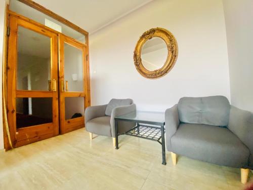 a living room with two chairs and a table and a mirror at Zajazd Jonatan in Czernin