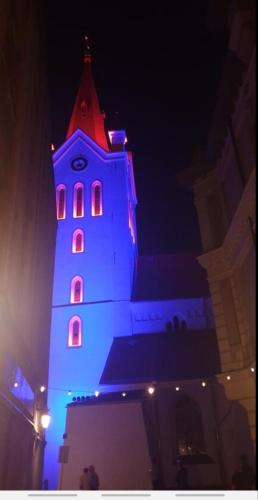 a building with a tower lit up at night at Estere in Cēsis