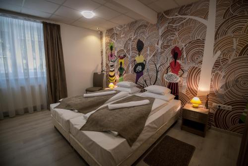 a bedroom with a bed with a wall mural at Mokka Apartman Szeged in Szeged