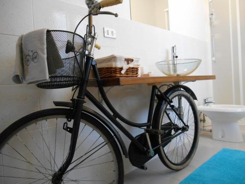 rower zaparkowany w łazience z umywalką w obiekcie B&B Alle Betulle w mieście Pievepelago