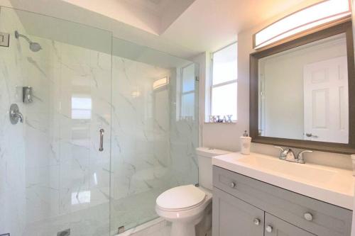 a bathroom with a shower and a toilet and a sink at Cheerfull 4/bed/ 3 Bath / pool / best Location in Naples