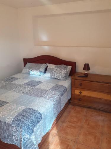 a bedroom with a bed and a wooden dresser at Tifrys in La Serena