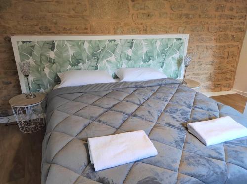a bedroom with a large bed with two towels on it at Appartement Cogny - les Meublés des Pierres Dorées in Theizé