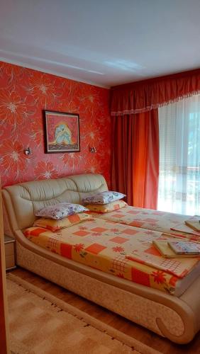 1 dormitorio con 1 cama grande y paredes rojas en Апартамент Златна дюна-Фешева, en Nesebar