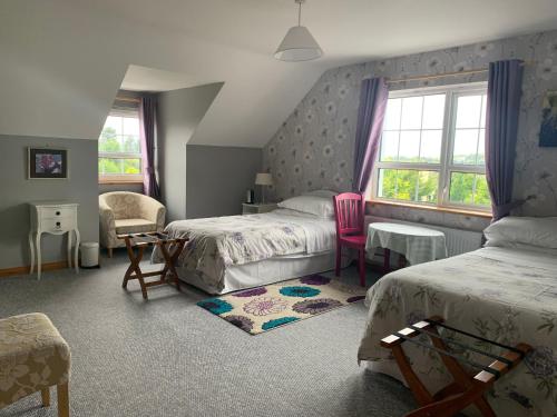 a bedroom with two beds and a table and chairs at Bayview Country House B&B in Ardara