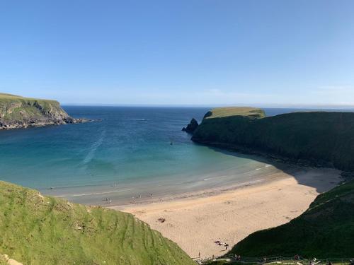 a view of a beach with people in the water at Bayview Country House B&B - F94 VK64 in Ardara