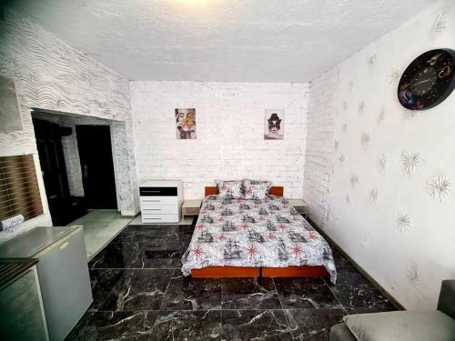 um quarto com uma cama e um relógio na parede em Топ Център едностаен! em Razgrad