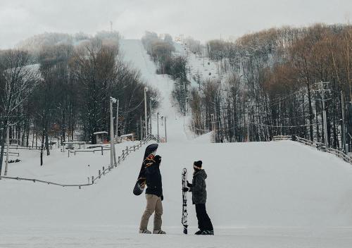 two people standing in the snow with their snowboards at Hotel Chateau Bromont in Bromont