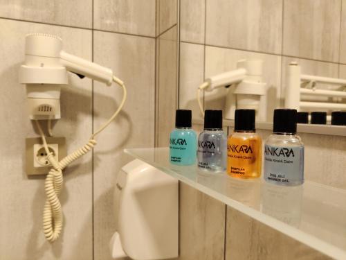 a bathroom with four bottles on a shelf next to a phone at CONCEPT HoUSE in Ankara