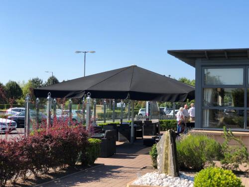 a large black umbrella sitting outside of a building at The Gailes Hotel & Spa in Irvine