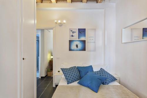 um sofá branco com almofadas azuis num quarto em Santina's House by Wonderful Italy em Génova