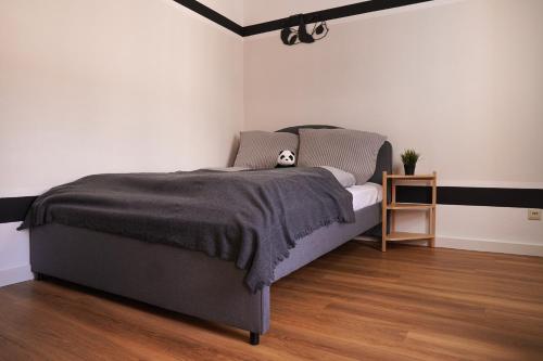 a bedroom with a bed with a gray bedspread at FULL HOUSE Studios - Panda Apartment - WiFi inkl in Halle an der Saale