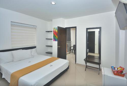 a bedroom with a bed and a television in it at La Pera Hotel in Bucaramanga