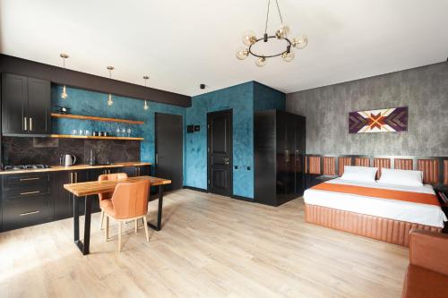 sypialnia z łóżkiem i stołem oraz kuchnia w obiekcie Irina's Apartments w Kutaisi