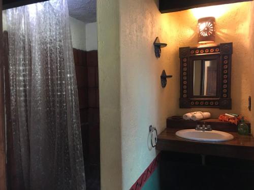 a bathroom with a sink and a shower curtain at Rancho Cumbre Monarca in La Ciénega