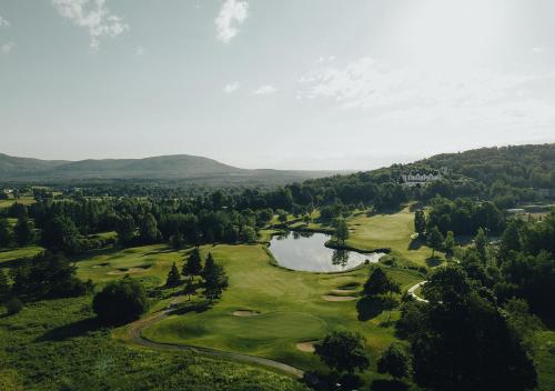 an aerial view of a golf course with a lake at Hotel Chateau Bromont in Bromont