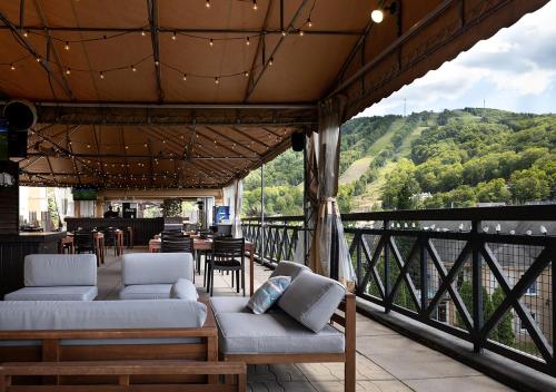 a balcony with couches and a table and chairs at Hotel Chateau Bromont in Bromont