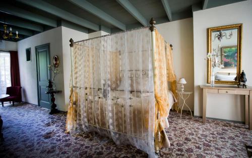 een slaapkamer met een hemelbed bij Stadslogement De Oude Smidse Steenwijk in Steenwijk