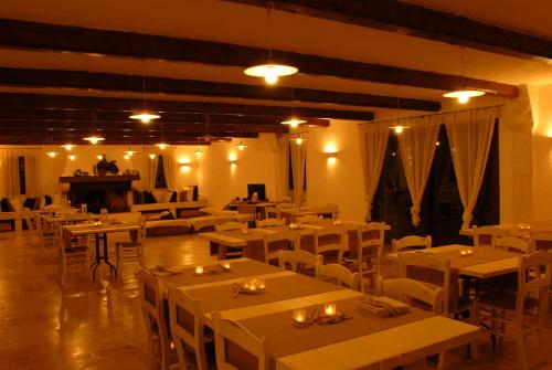 a restaurant with white tables and chairs and a piano at Agriturismo Iazzo Scagno in Martina Franca