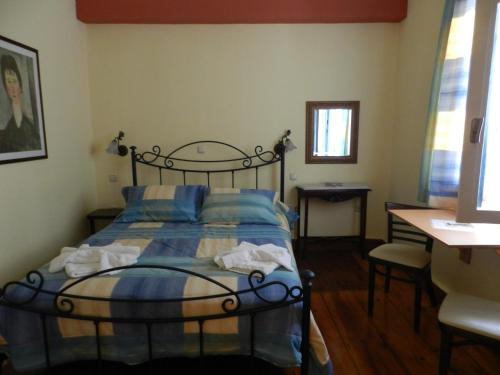 1 dormitorio con 1 cama, mesa y sillas en En Ermoupoli, en Ermoupoli