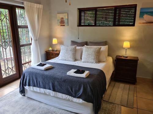 クニスナにあるSyringa Cottage Family Hideawayのベッドとタオル2枚のある寝室
