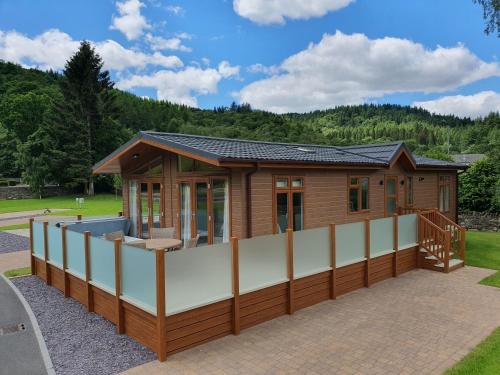 a modular house with a large deck and a building at Llyn Dinas Lodge in Betws-y-coed