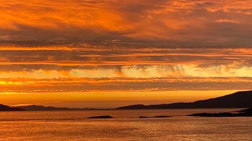 a sunset over the water with mountains in the background at Heatherbrae Guest House in Kyle of Lochalsh