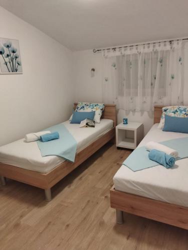 a room with two beds with blue pillows at Holiday home Silva in Peruški