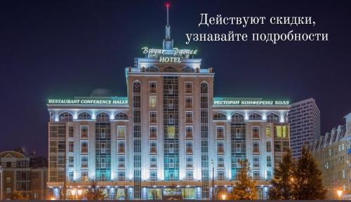 a large building with a green sign on top of it at Bilyar Palace in Kazan