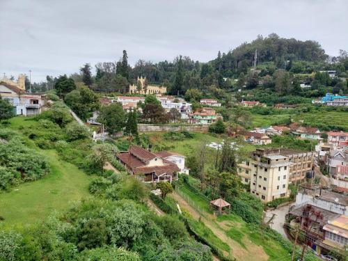 eine Stadt auf einem Hügel mit Häusern und Bäumen in der Unterkunft Astoria Residency in Udagamandalam
