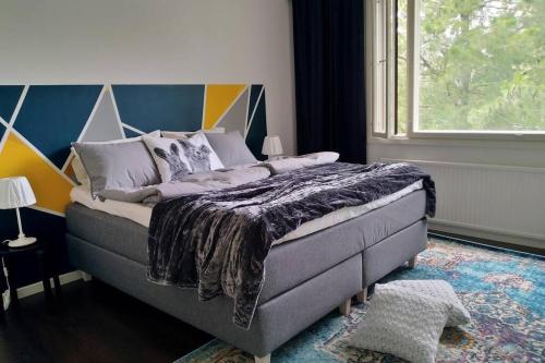 uma cama num quarto com uma grande janela em Apartment with two bedrooms and a parking space em Vantaa