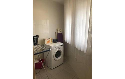 a laundry room with a washing machine and a window at Casa do Meio in Paredes