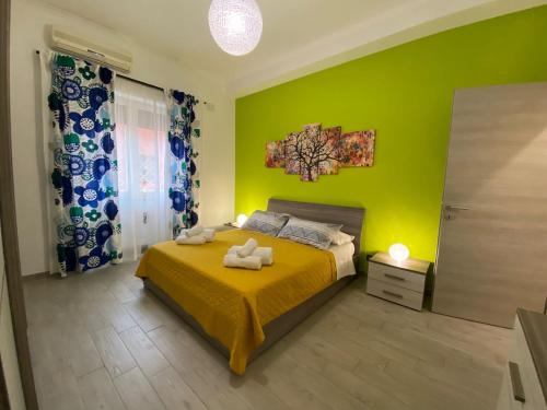 a green bedroom with a bed with two towels on it at Mimma’s house Monteverde in Rome