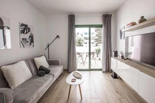 a living room with a couch and a television at Holyhome premium 109 in Costa Teguise