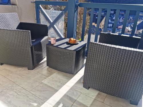 three wicker chairs and a plate of food on a balcony at Appartement d'une chambre avec balcon a Cauterets in Cauterets