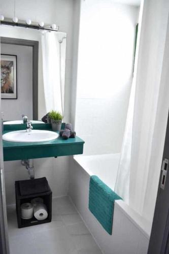 a bathroom with a sink and a tub and a mirror at HOLYHOME APARTMENT 208 in Costa Teguise