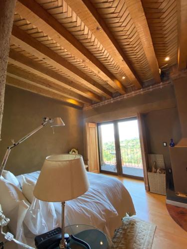 a bedroom with a bed and a lamp and a window at Hacienda Ucazanaztacua in Pátzcuaro