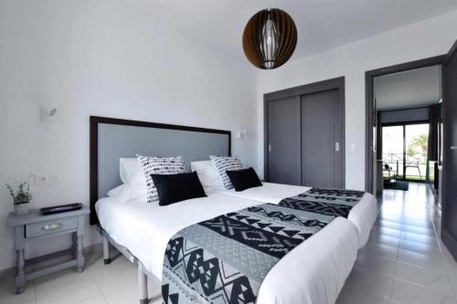 um quarto com uma cama grande e um cobertor preto e branco em Holyhome apartment 204 em Costa Teguise