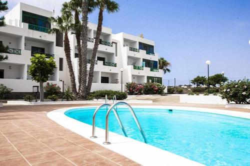 a swimming pool in front of a apartment building at Holyhome premium in Costa Teguise