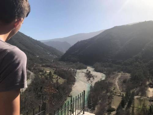 a man standing on top of a mountain looking at a valley at Chambre campagnarde in Roquestéron